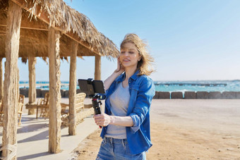 中间岁的女人智能<strong>手机网</strong>络摄像头会说话的记录视频桑迪海滩