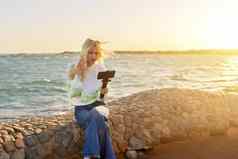 女少年智能手机三脚架海日落海滩记录视频