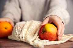 女手环境友好的网袋购物食品杂货新鲜的水果苹果橙子生态友好的网木表格