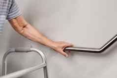 上了年纪的女人持有扶手安全走步骤