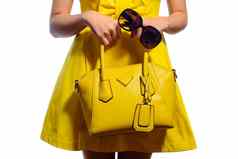 优雅的时尚女人黄色的衣服手提包太阳镜
