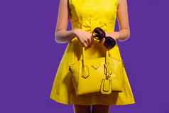 优雅的时尚女人黄色的衣服手提包太阳镜