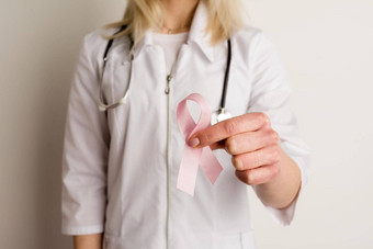 女人医生持有粉红色的丝带手