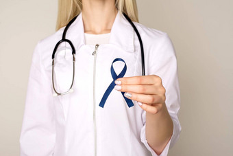 医生手持有蓝色的丝带糖尿病结直肠癌症意识