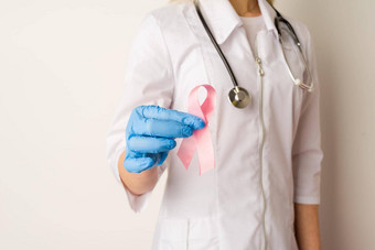 女人医生持有粉红色的丝带手