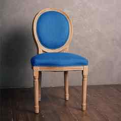 蓝色的豪华的古董椅子站黑暗木地板上