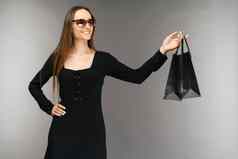 黑色的星期五出售概念购物女人持有袋孤立的背景假期