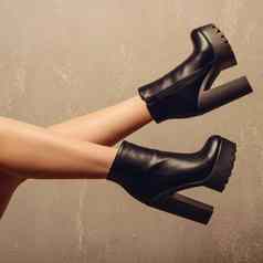 女人的高非常黑色的皮革靴子