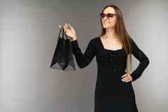 黑色的星期五出售概念购物女人持有袋孤立的背景假期