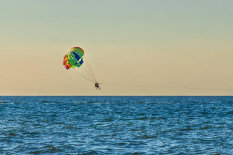 男人。女人游客飞行帆伞运动海背景日落天空地平线极端的假期概念