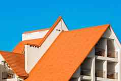 几何现代建筑外观橙色平铺的屋顶酒店海蓝色的天空