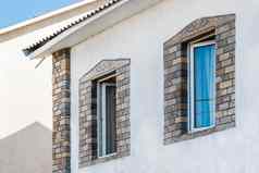 部分现代室内外观房子白色石膏墙装饰石头模式开放双上釉窗户