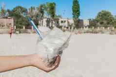 女孩的手持有塑料袋垃圾海滩概念污染生态浪费处理