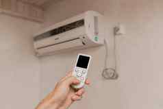 盖伊手持有远程控制空气护发素冷却温度控制房间房子