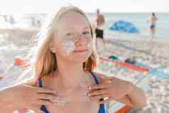 肖像年轻的积极的十几岁的女孩金发女郎欧洲外观防晒霜脸身体背景海海滩
