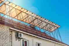 太阳能面板屋顶建筑蓝色的阳光明媚的天空明亮的镜头耀斑