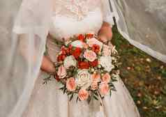 新娘的手持有婚礼装饰花束花玫瑰