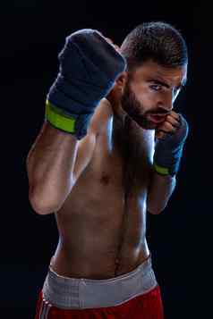 拳击男人。准备好了战斗拳击手强大的手握紧的拳头蓝色的肩带黑色的背景