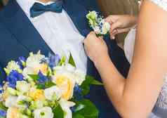 手年轻的新娘正确的小花蓝色的西装新郎婚礼花束手