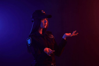 红发的<strong>女警</strong>察官摆姿势相机黑色的背景红色的蓝色的背光