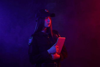 红发的<strong>女警</strong>察官摆姿势相机黑色的背景红色的蓝色的背光