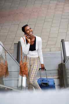 快乐非洲美国女人站自动扶梯旅行袋会说话的手机