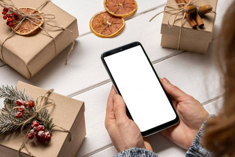 智能<strong>手机</strong>女人的手圣诞<strong>节</strong>礼物盒子背景在线购物概念