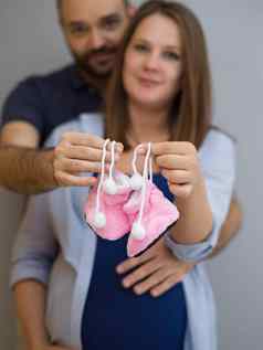 怀孕了夫妇持有新生儿婴儿鞋子