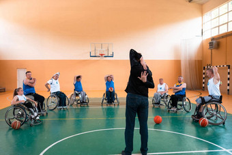 选择器篮球团队残疾站前面球员显示伸展运动练习开始培训