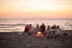 集团年轻的朋友坐着火海滩