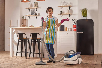年轻的女人真空更清洁的首页厨房地板上清洁职责家务一丝不苟的室内