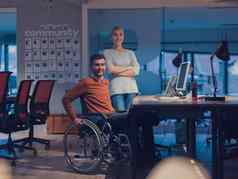 商人轮椅现代共同办公办公室空间工作晚些时候晚上办公室的同事们背景残疾障碍概念
