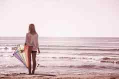 年轻的女人风筝海滩秋天一天