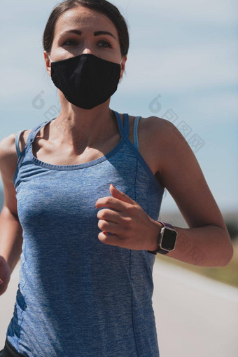 确定健身女人短衣服穿红色的保护脸面具运行在户外城市冠状病毒爆发科维德物理慢跑活动体育运动健身