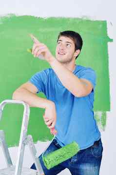 英俊的年轻的男人。油漆白色墙颜色