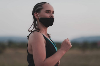 确定健身女人短衣服穿红色的保护脸面具运行在户外城市冠状病毒爆发科维德物理慢跑活动体育运动健身