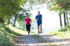 夫妇享受健康的生活方式慢跑国家路