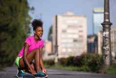 非洲美国女人跑步者收紧鞋花边