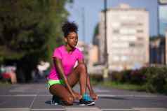 非洲美国女人跑步者收紧鞋花边