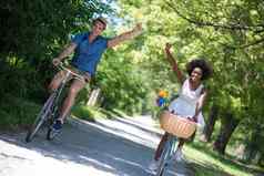 年轻的多民族夫妇自行车骑自然
