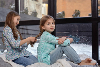 图像可爱的姐妹坐着窗台上和平安静的