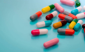 抗生素胶囊药片蓝色的背景处方药物色彩斑斓的胶囊药片抗生素药物电阻概念制药行业超级细菌问题药药理学