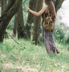 有吸引力的嬉皮女孩走森林路径