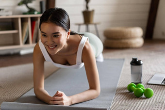 运动亚洲女孩<strong>运动服</strong>锻炼<strong>首页</strong>遵循视频体育运动指南在线健身教练移动PC站板材地板上席