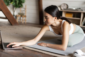 亚洲女孩瑜伽伸展运动首页锻炼生活房间移动PC屏幕看<strong>健身视频</strong>在线电脑