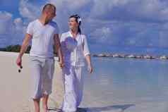 快乐年轻的夫妇夏天假期有趣的放松海滩