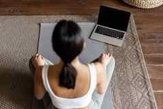 正念冥想概念后视图年轻的亚洲女人冥想首页在线移动PC坐着生活房间地板上席