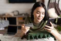 年轻的亚洲女人购买在线商店移动电话信贷卡购物首页