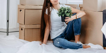 年轻的女人首页植物坐着地板上生活房间