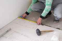 工人安装陶瓷木效果瓷砖地板上